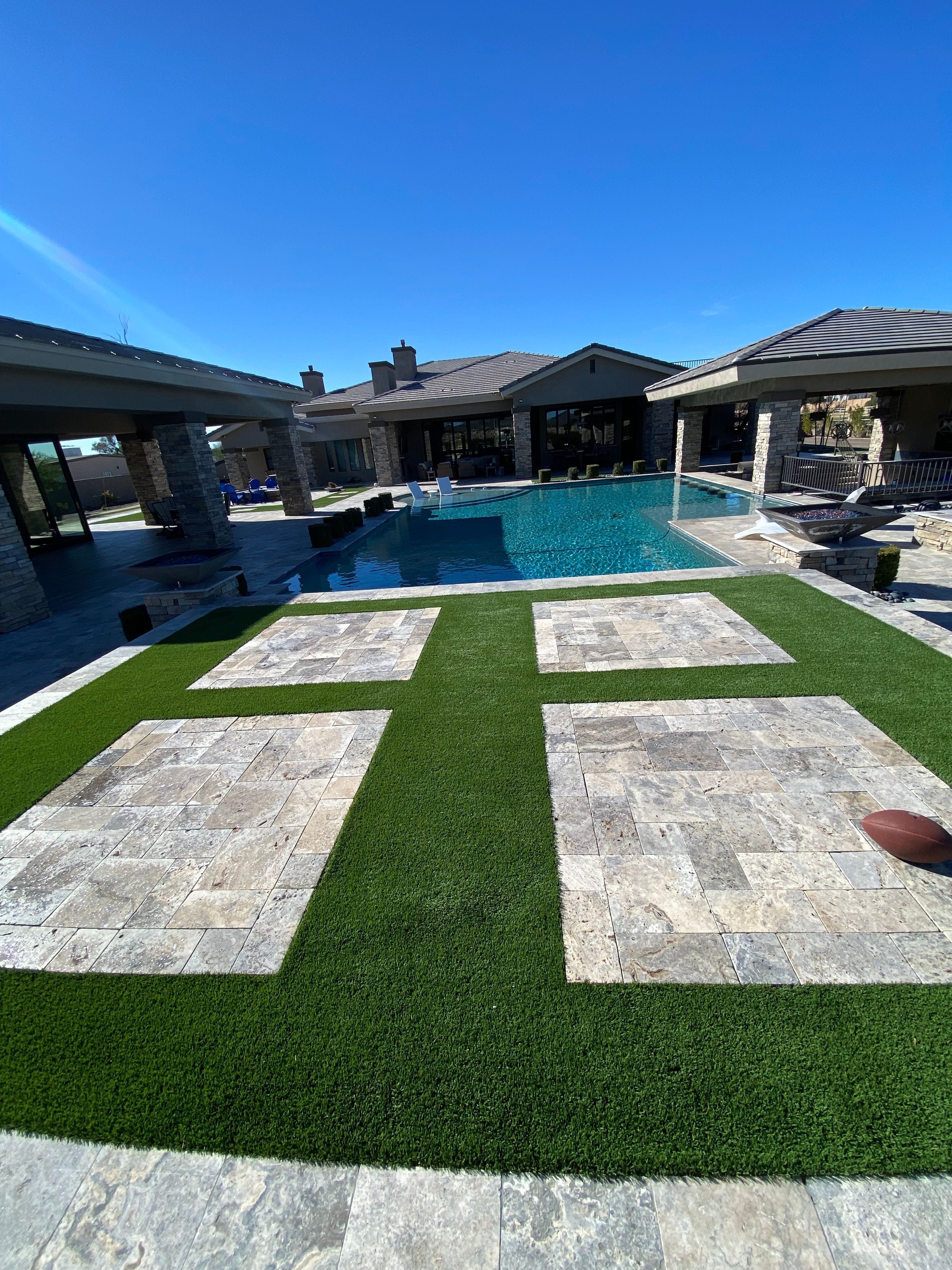 Artificial turf beside a backyard pool, professionally cleaned by Zeo Turf Cleaning